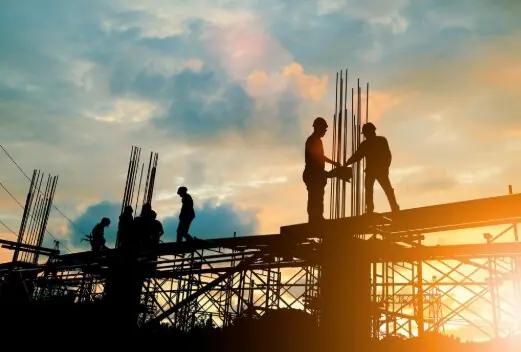 Equipe trabalhando em obra ao entardecer